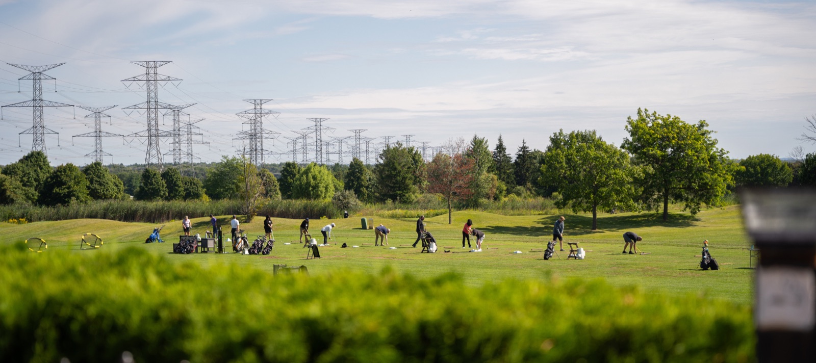 Golfers practicing on the grass driving range at Deer Creek Practice and Performance Centre in Ajax